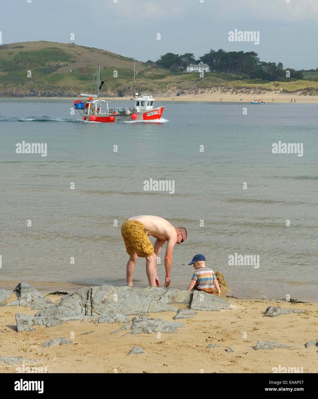 A man playing with his son on the beach in the Camel estuary,Padstow,Cornwall, England uk Stock Photo