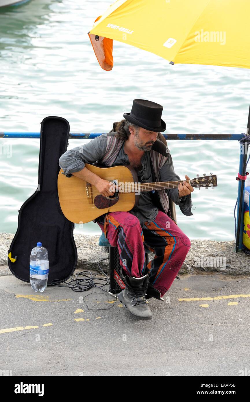 A busker performing on Padstow seafront Cornwall England uk Stock Photo