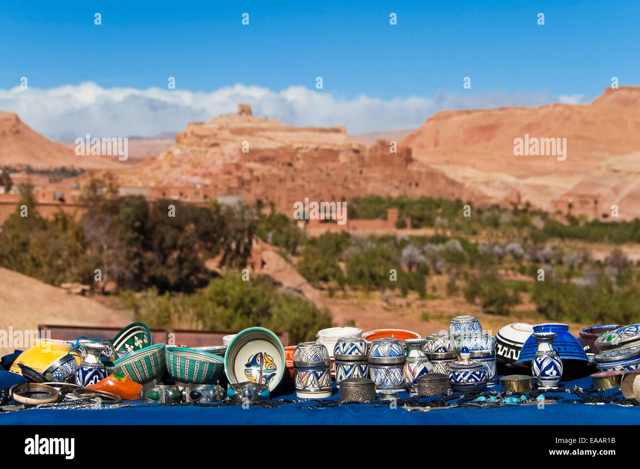 Horizontal close up of traditional Moroccan handicrafts on the roadside with Ait Benhaddou kasbah in the background. Stock Photo
