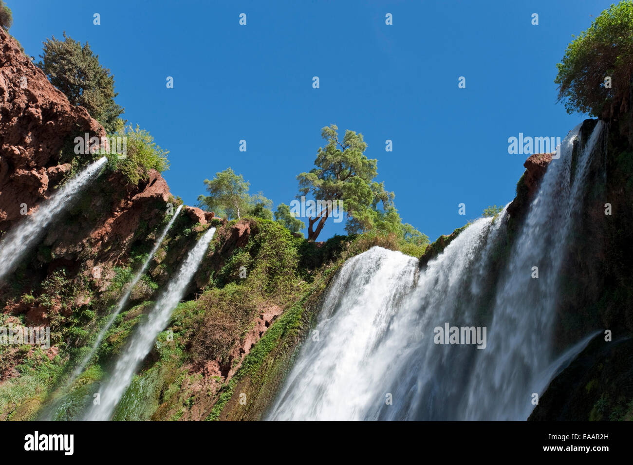 Horizontal view of water spilling over Cascades d'Ouzoud on a sunny day. Stock Photo