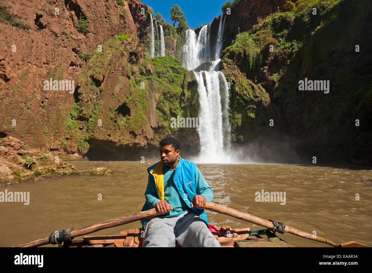 Horizonal portrait of a young Moroccan man rowing a tour boat at the bottom of Cascades d'Ouzoud Stock Photo