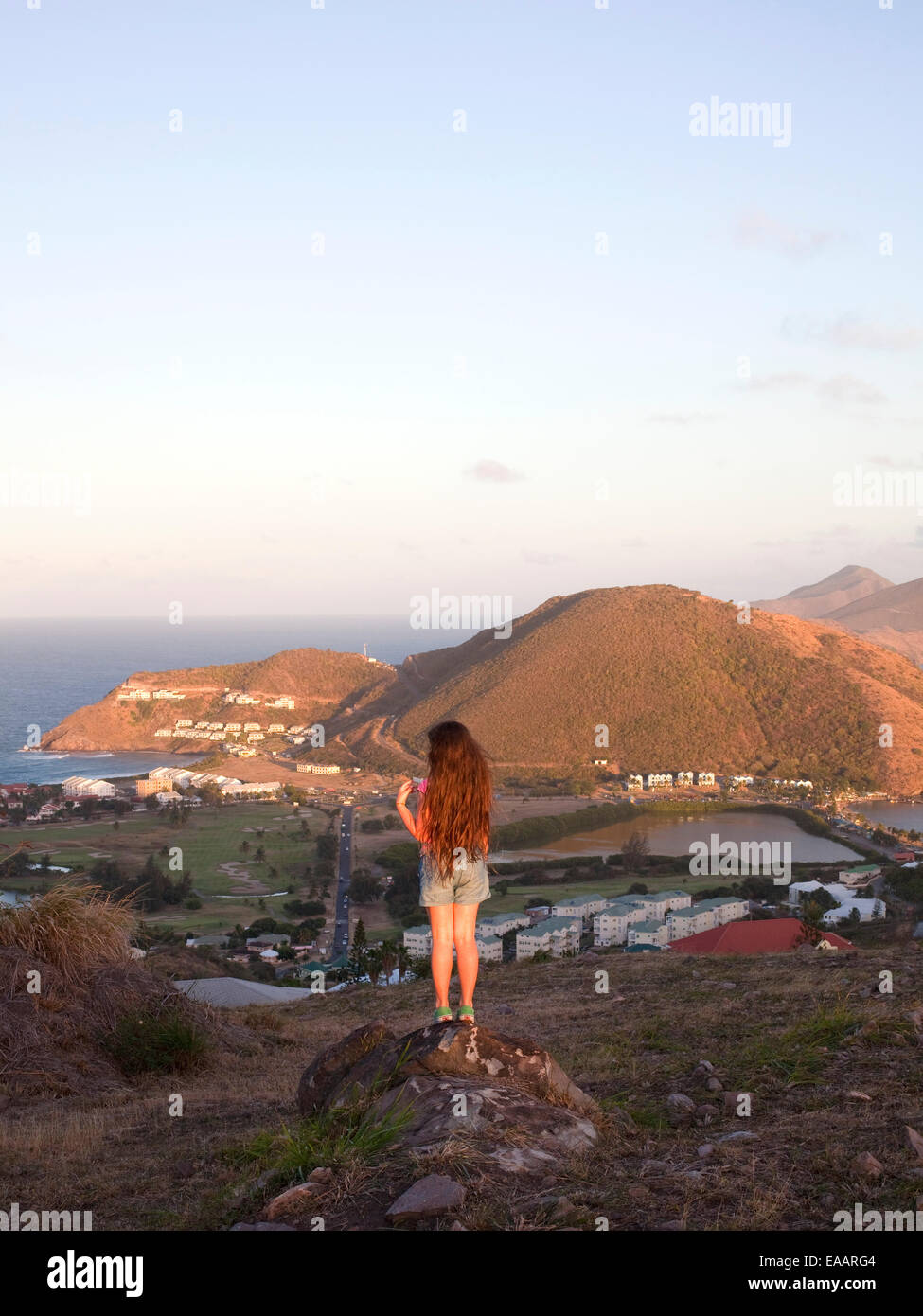 girl standing on rock looking at view of St. Kitts Stock Photo