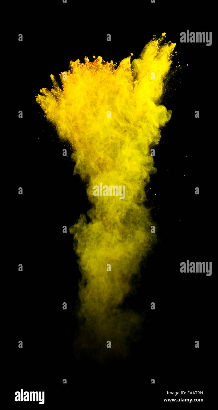 Freeze motion of yellow dust explosion isolated on black background Stock Photo