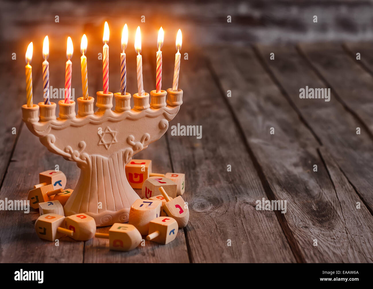 Jewish holiday hannukah symbols - menorah and wooden dreidels. Copy space background. Stock Photo