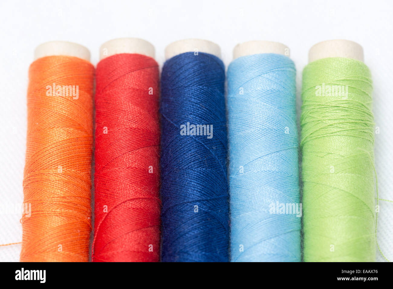 set of colorful spools of thread on a white background Stock Photo - Alamy
