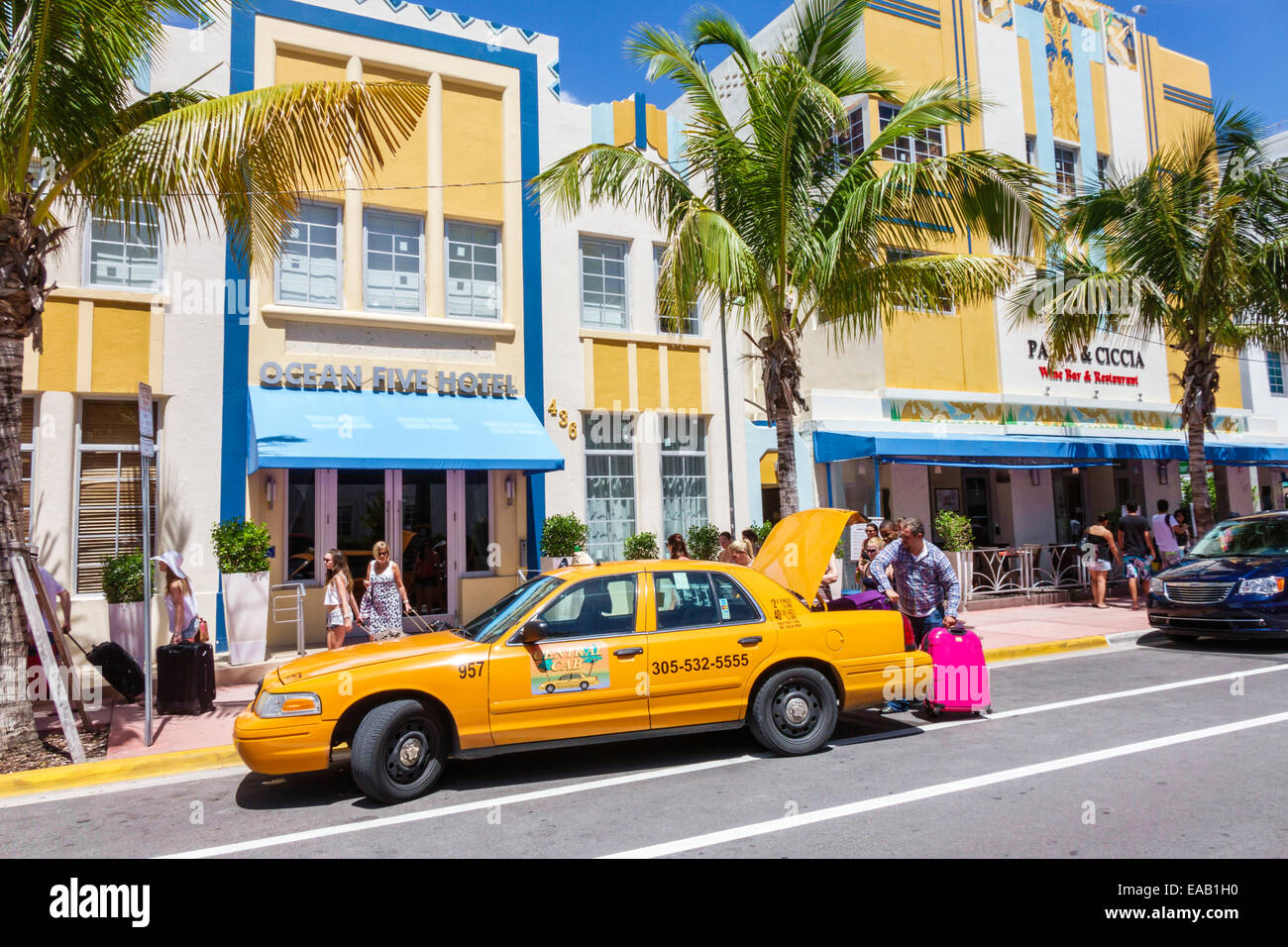 Miami Beach Florida,Ocean Drive,Ocean Five,hotel,hotel,hotels,taxi cab,yellow,driver,putting luggage in trunk,FL140823001 Stock Photo