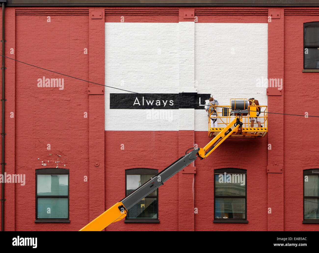 Men painting a sign on the facade of a building, Lancaster, Pennsylvania, USA Stock Photo