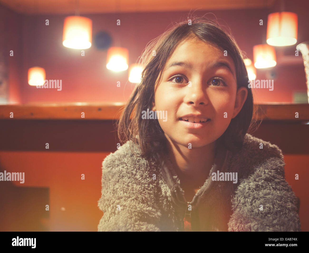 Girl sits at tab;e in restaurant Stock Photo