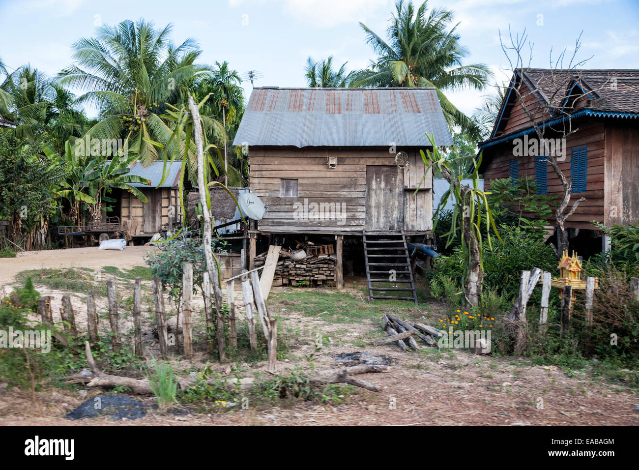 Cambodia.  Poor Rural House, with Living Quarters above the Ground-level Storage Area.  Note TV Antenna on Roof, Satellite Dish, Stock Photo