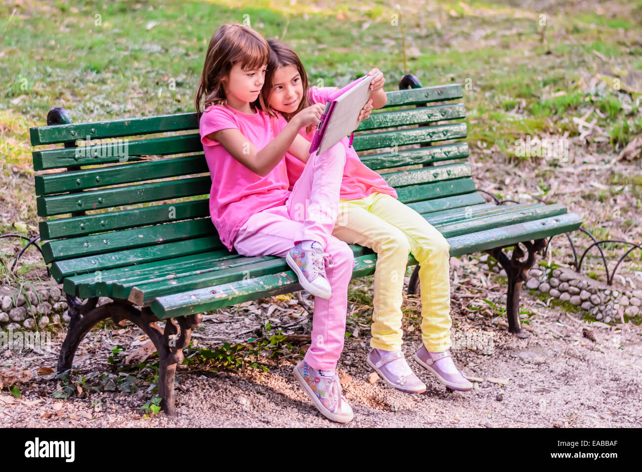 Two sisters reading in the Park Stock Photo