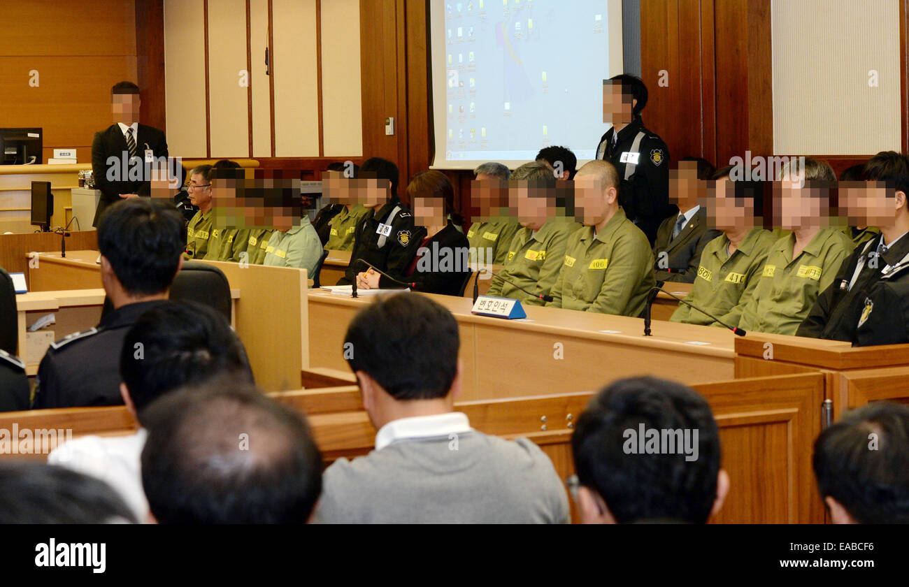 Seoul, South Korea. 11th Nov, 2014. Sewol ferry captain Lee Joon-seok (man  in green, with glasses) sits with crew members at the start of the verdict  proceedings in a court room in