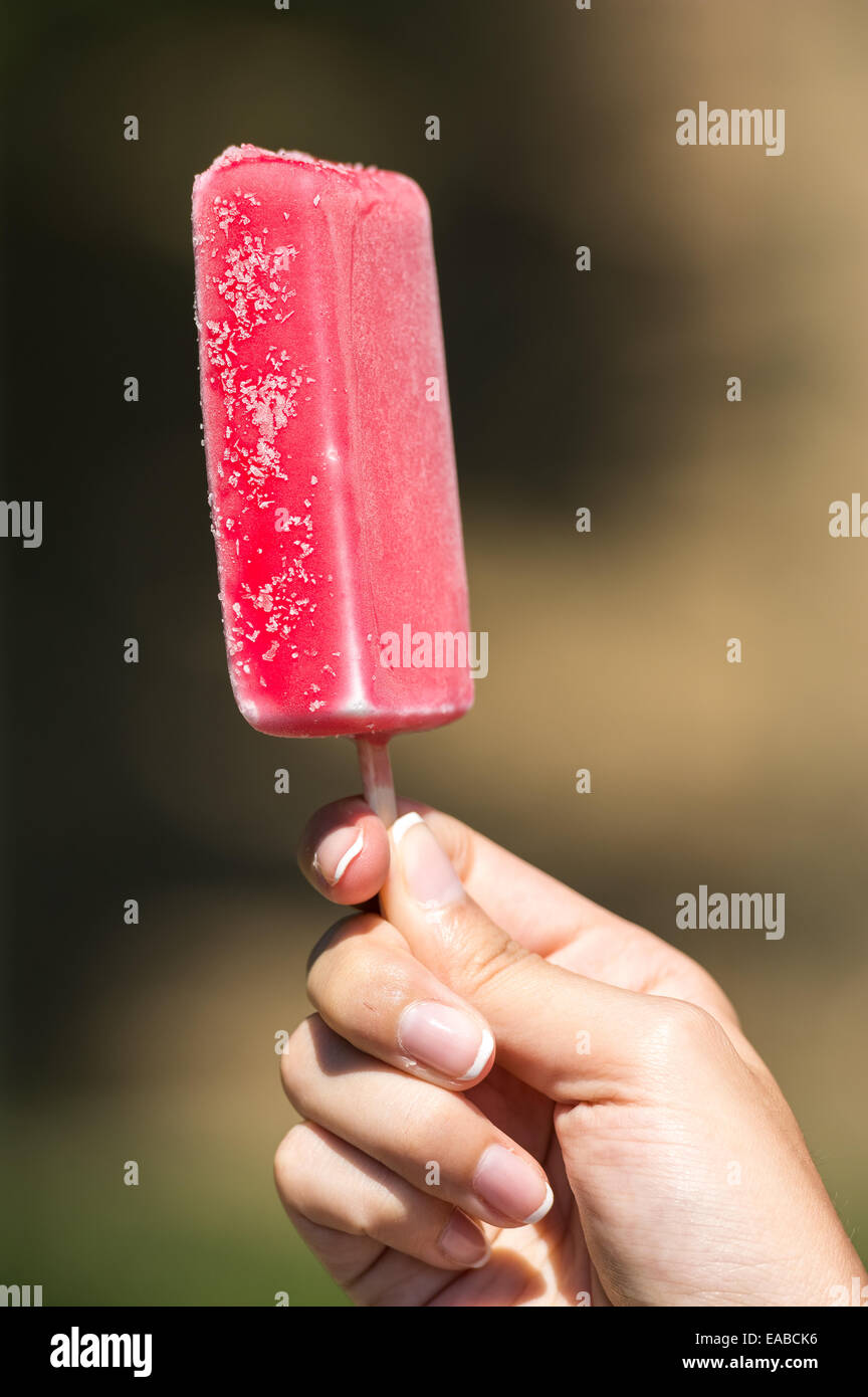 Girl Hand Holding Pink Ice Cream On Stick Stock Photo
