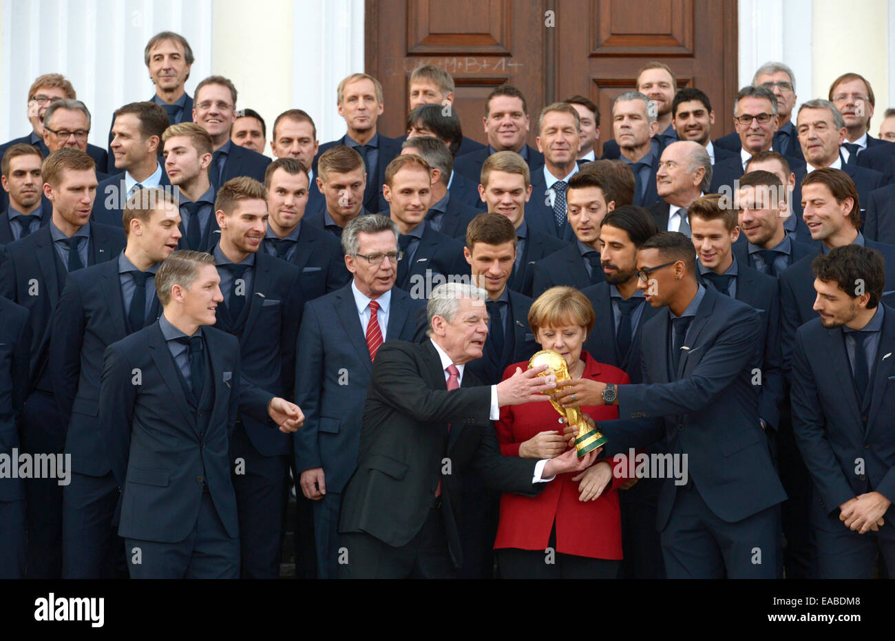 Berlin, Germany. 10th Nov, 2014. German President Joachim Gauck, Chancellor Angela Merkel, and Minister of the Interior Thomas de Maziere stand together with the 23 soccer world champions in front of Bellevue Castle in Berlin, Germany, 10 November 2014. The German soccer national team is honored with the award 'Silbernes Lorbeerblatt' for winning the 2014 world cup in Brazil. PHOTO: RAINER JENSEN/dpa/Alamy Live News Stock Photo