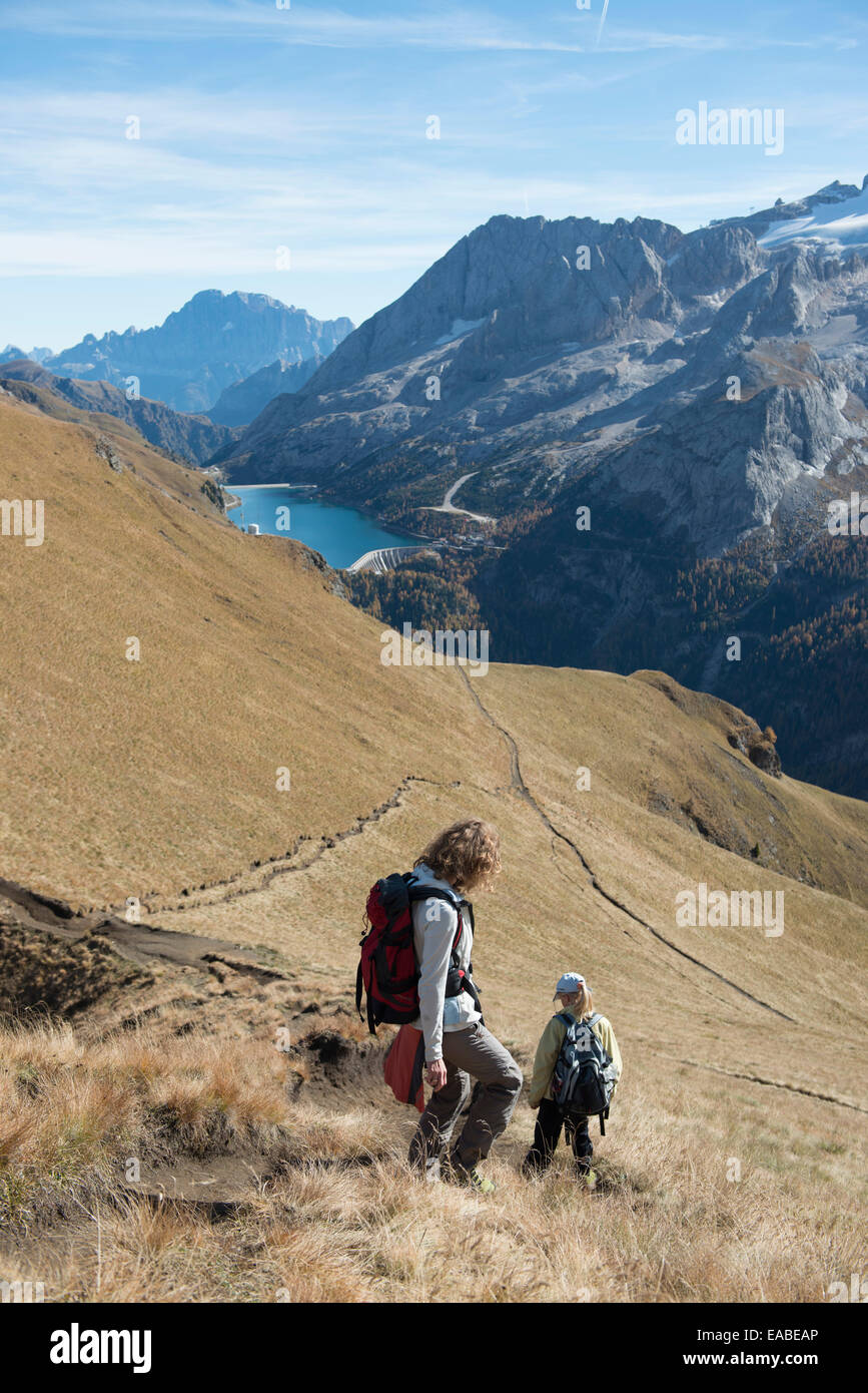 Frau und Kind wandern auf Schotterweg Woman and children hiking on alpine way Stock Photo