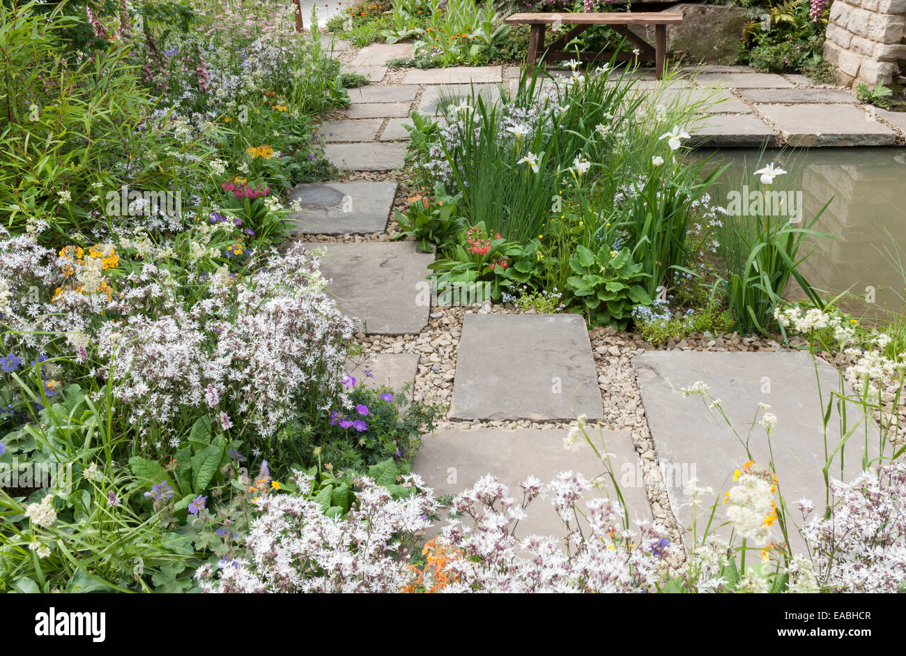 paved small garden by pond photographed at rhs chelsea flower show Stock Photo