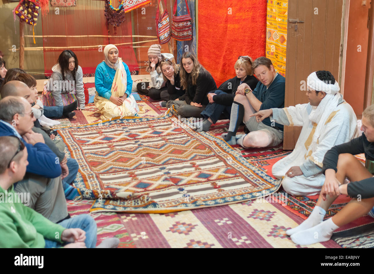 Moroccan rug sellers showing traditional berber carpets to tourists. Morocco, Africa Stock Photo