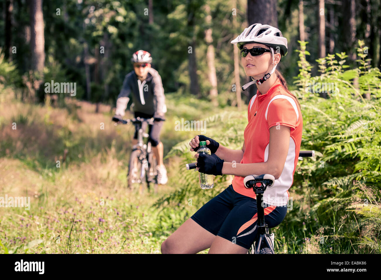A cycling woman in front of the forest Stock Photo - Alamy