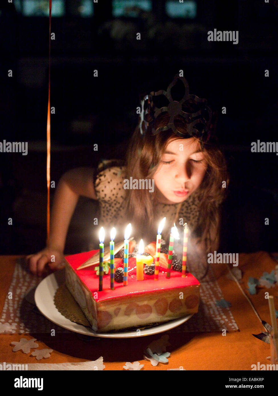 young girl blowing out the candles on her birthday cake Stock Photo
