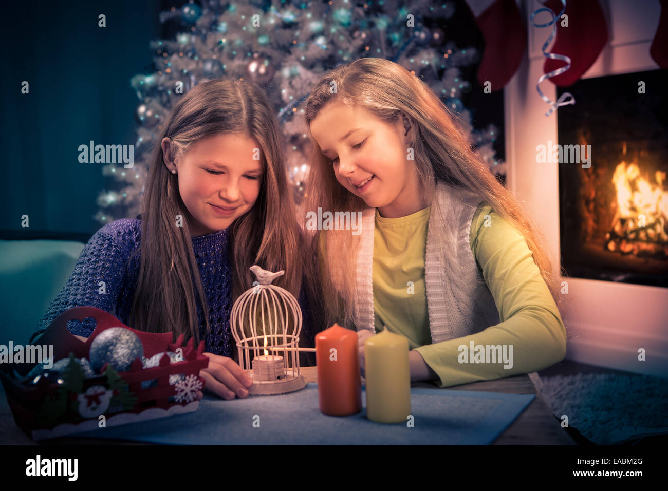 two teenage girls with christmas lights at home Stock Photo
