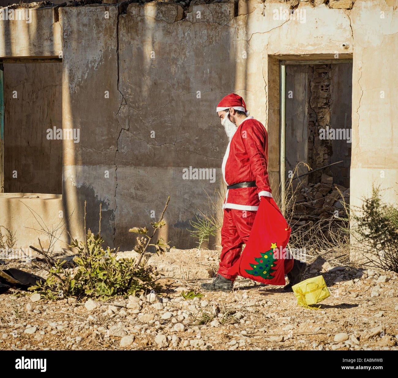 A fed up  Santa trudging along with his sack Stock Photo
