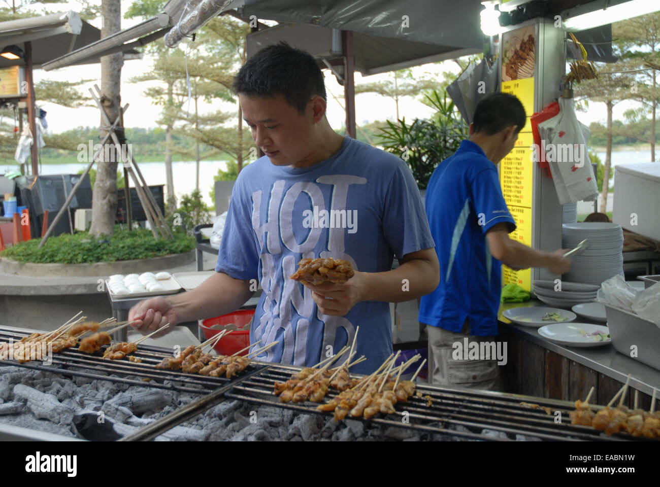Man cooking satay at  Satay By The Bay food center, Marina Bay, Singapore. Stock Photo
