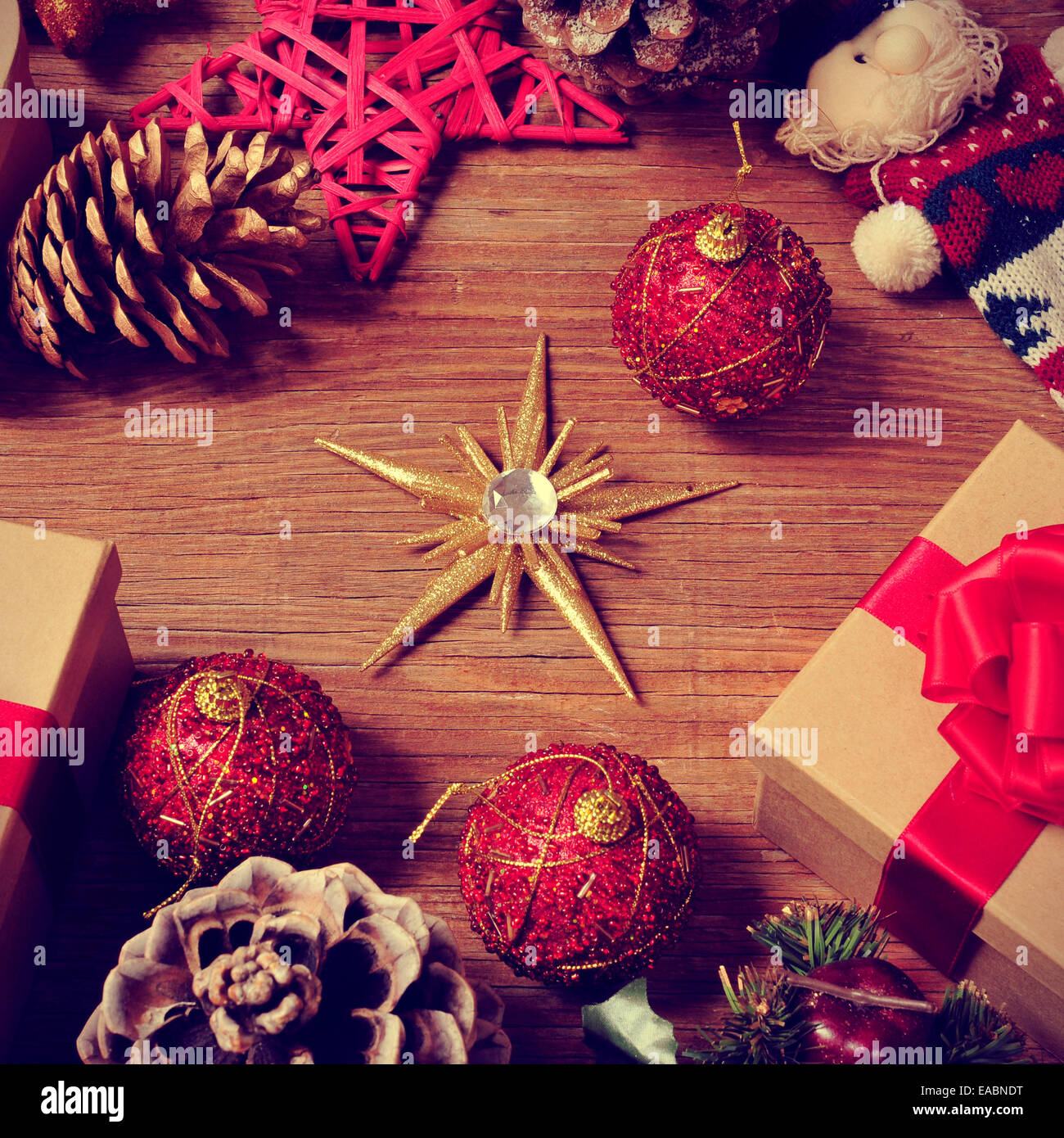 a pile of gifts and christmas ornaments, such as christmas balls and stars, on a rustic wooden table Stock Photo