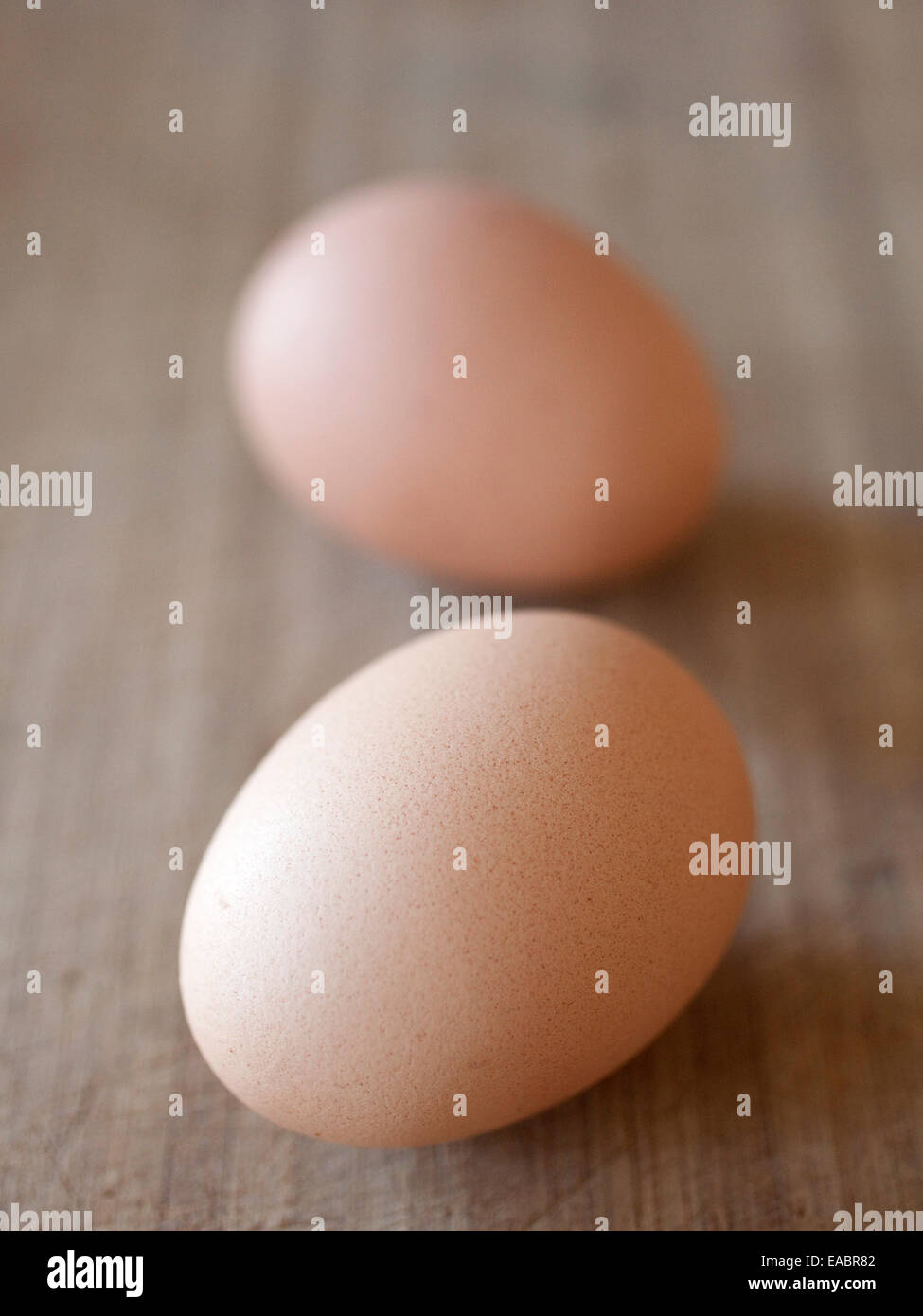 Two brown eggs on a wood surface. Stock Photo