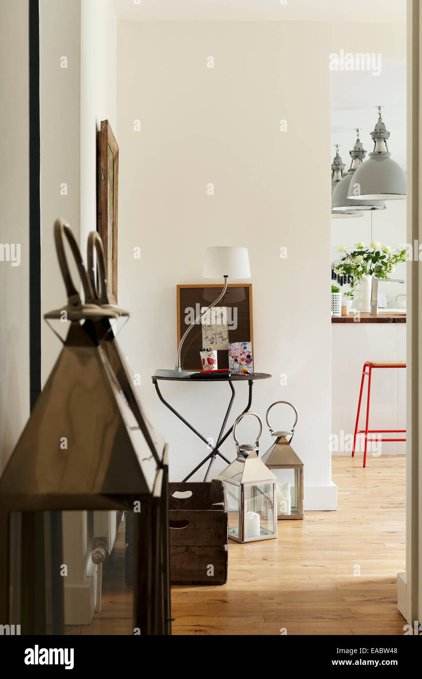 Pair of chrome and glass storm lanterns in hallway with french cross legged side table Stock Photo