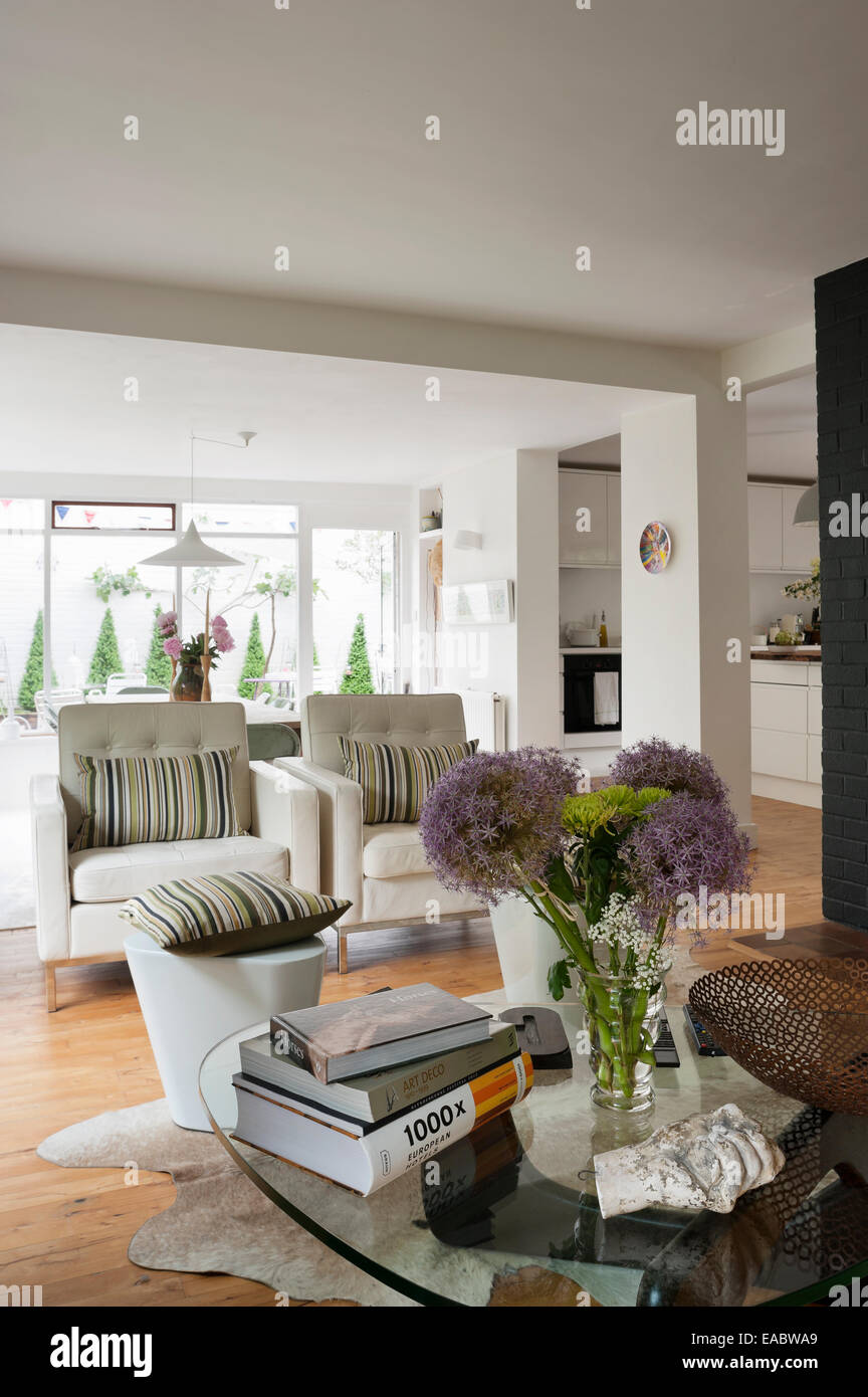 Vase of flowers on glass topped coffee table in open plan living space ...