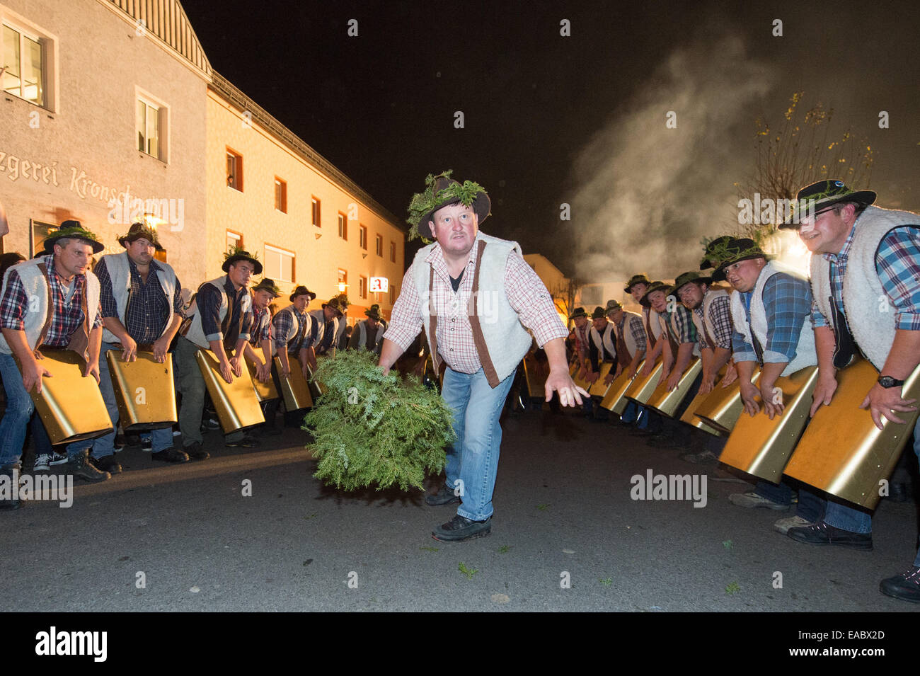 Participants in the 'Wolfsauslassen' (a local custom in the Bavarian Forest) ring large cow bells in Rinchnach, Bavaria, 10 November 2014. Around 600 boys and some girls come together every year for 'Wolfsauslassen.' According to old customs, the threatening sound of the bell chimes is meant to scare away wild animals. Photo: Armin Weigel/dpa Stock Photo