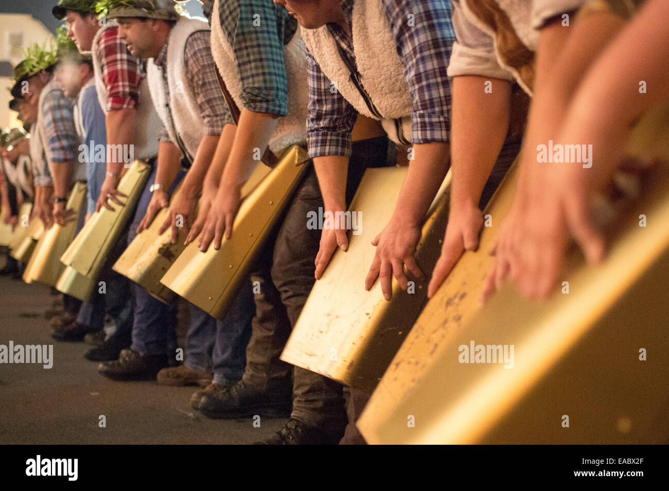 Participants in the 'Wolfsauslassen' (a local custom in the Bavarian Forest) ring large cow bells in Rinchnach, Bavaria, 10 November 2014. Around 600 boys and some girls come together every year for 'Wolfsauslassen.' According to old customs, the threatening sound of the bell chimes is meant to scare away wild animals. Photo: Armin Weigel/dpa Stock Photo