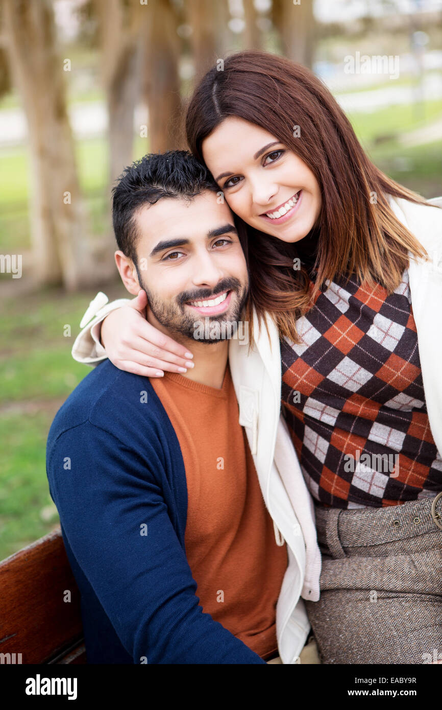 Young romantic couple on a bench in park Stock Photo - Alamy