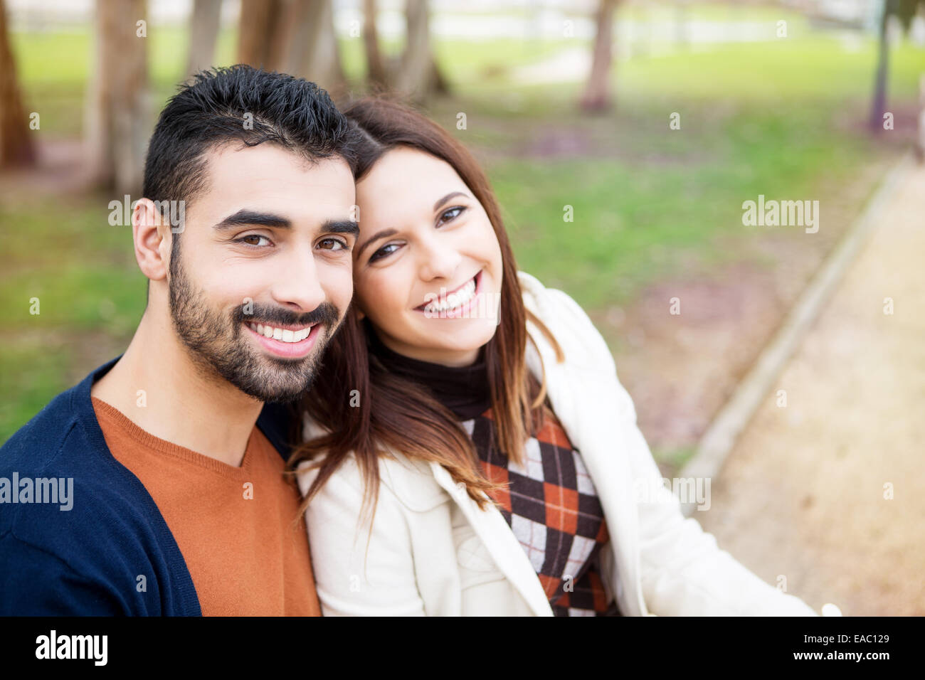 Young romantic couple on a bench in park Stock Photo - Alamy