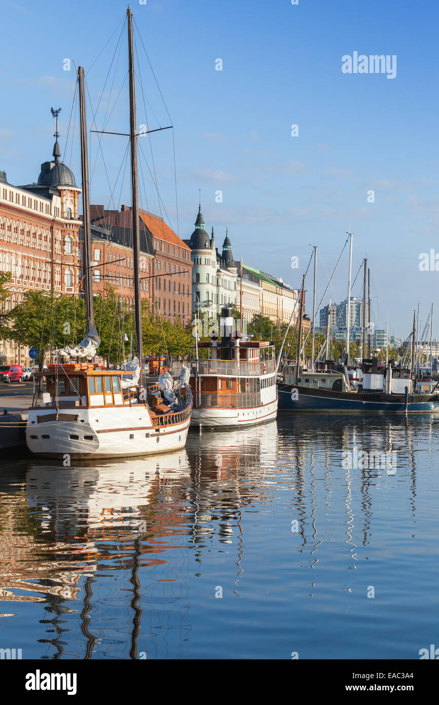 Old quay of Helsinki city with moored sailing ships and classical building facades in the morning light Stock Photo