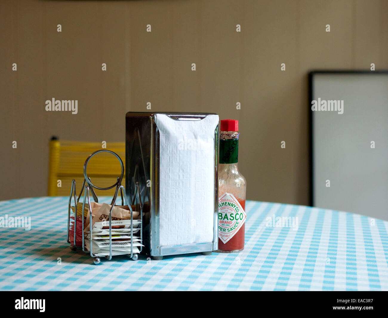 blue gingham wax table clothe with napkins and condiments at diner Stock Photo