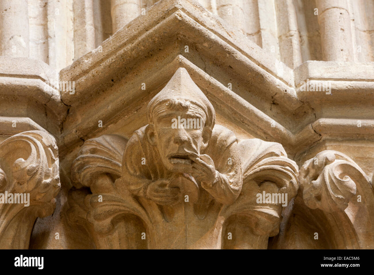 A medieval tone carved capital: man with toothache, Wells Cathedral Stock Photo