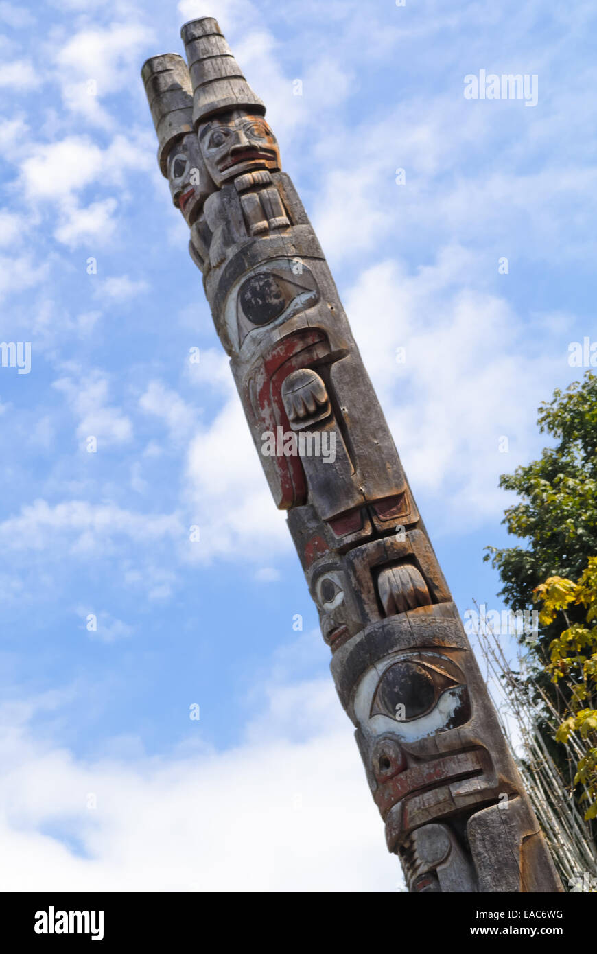 First Nations' Haida totem pole carving against blue sky Stock Photo