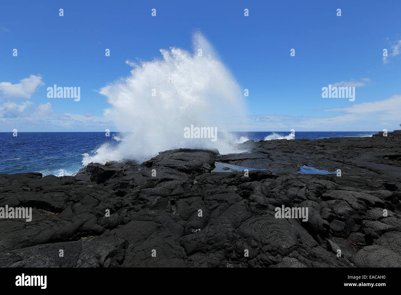 Ocean waves crash on the lava rocky coast of the big island of Hawaii Stock Photo