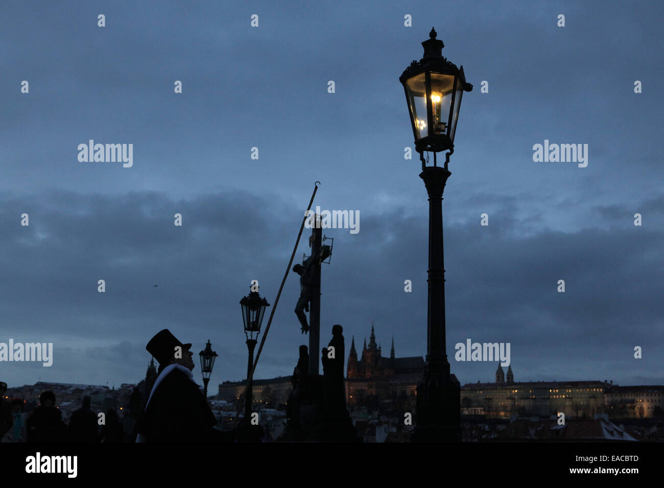 Lamplighter lights a street gas light manually during the Advent time at the Charles Bridge in Prague, Czech Republic. Street ga Stock Photo