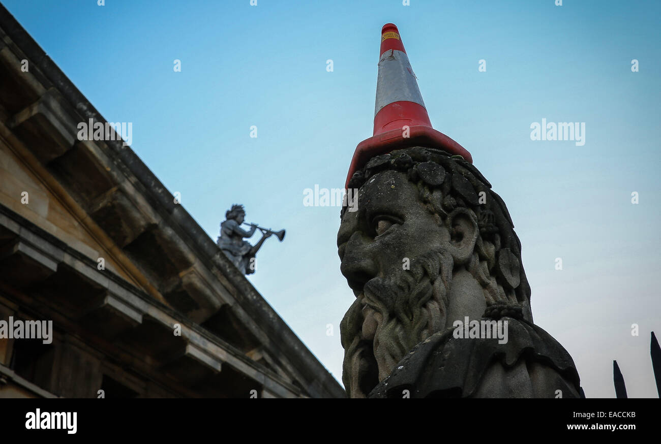Prankster puts traffic cone in one of the emperors head at Sheldonian theater in Oxford Stock Photo