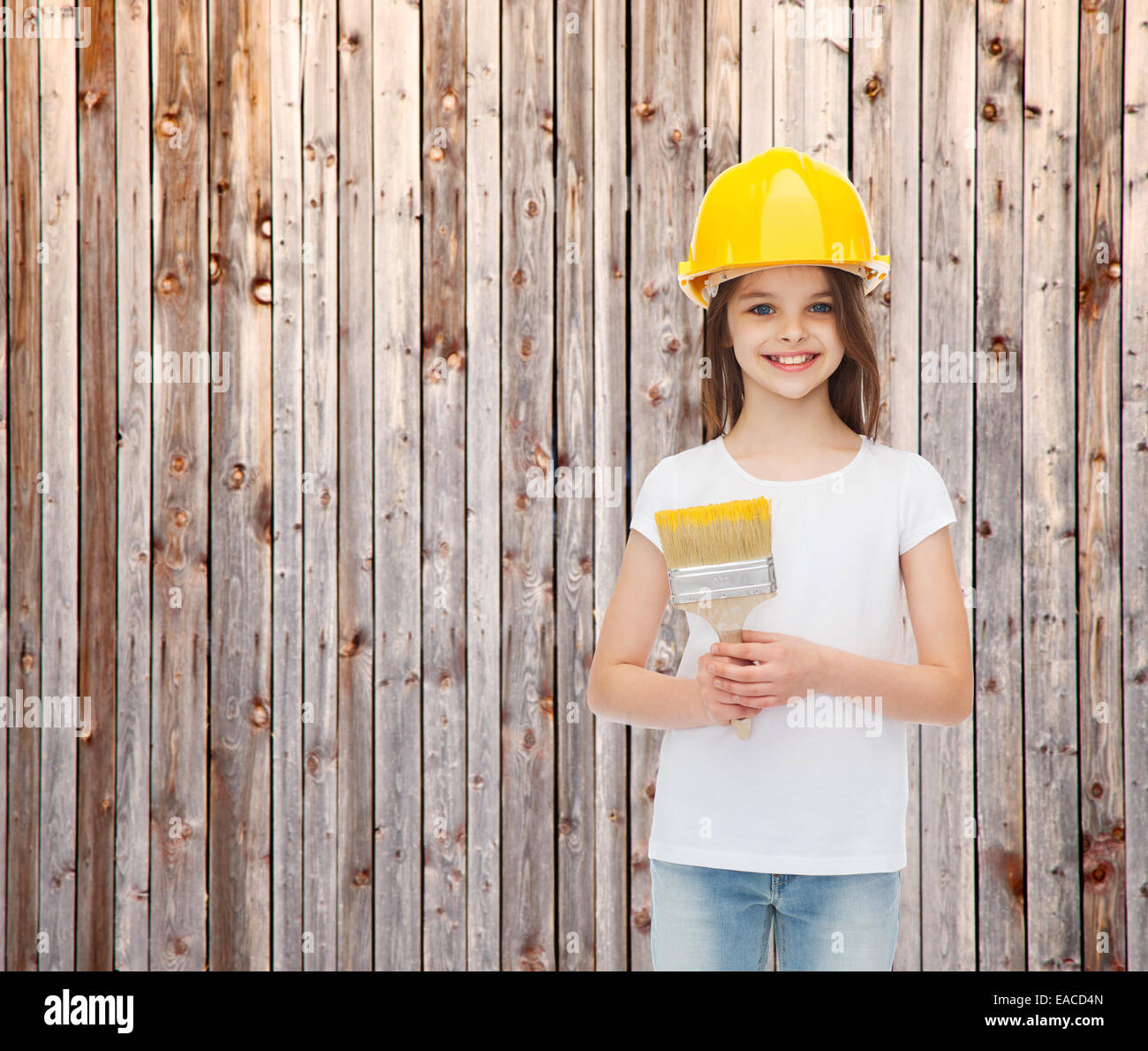 smiling little girl in helmet with paint brush Stock Photo