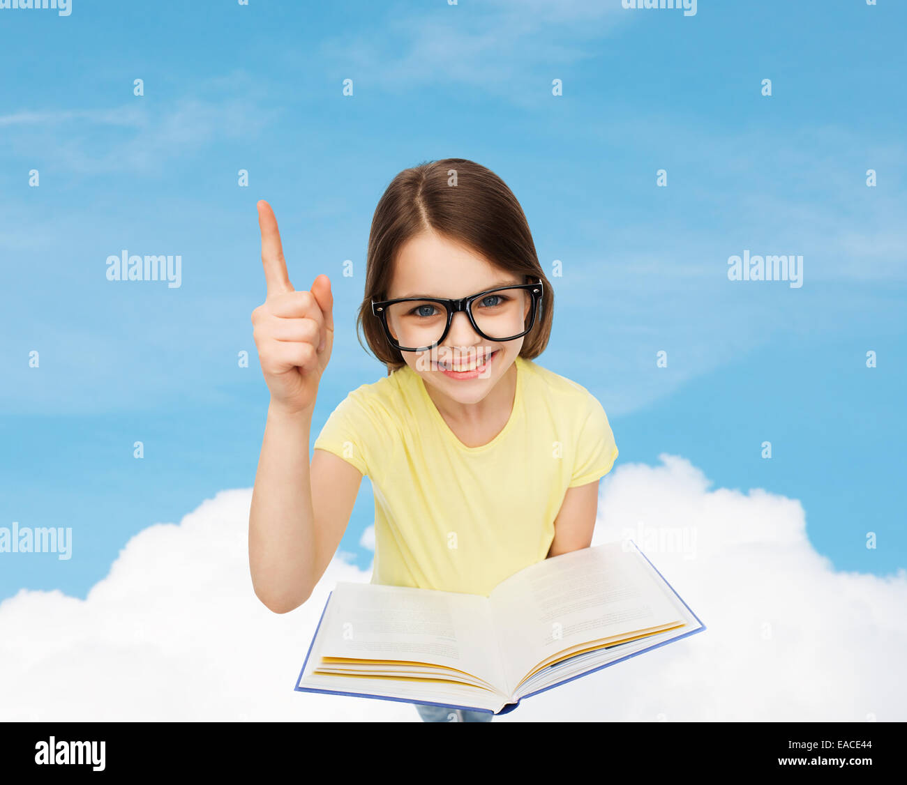 smiling little girl in eyeglasses with book Stock Photo - Alamy