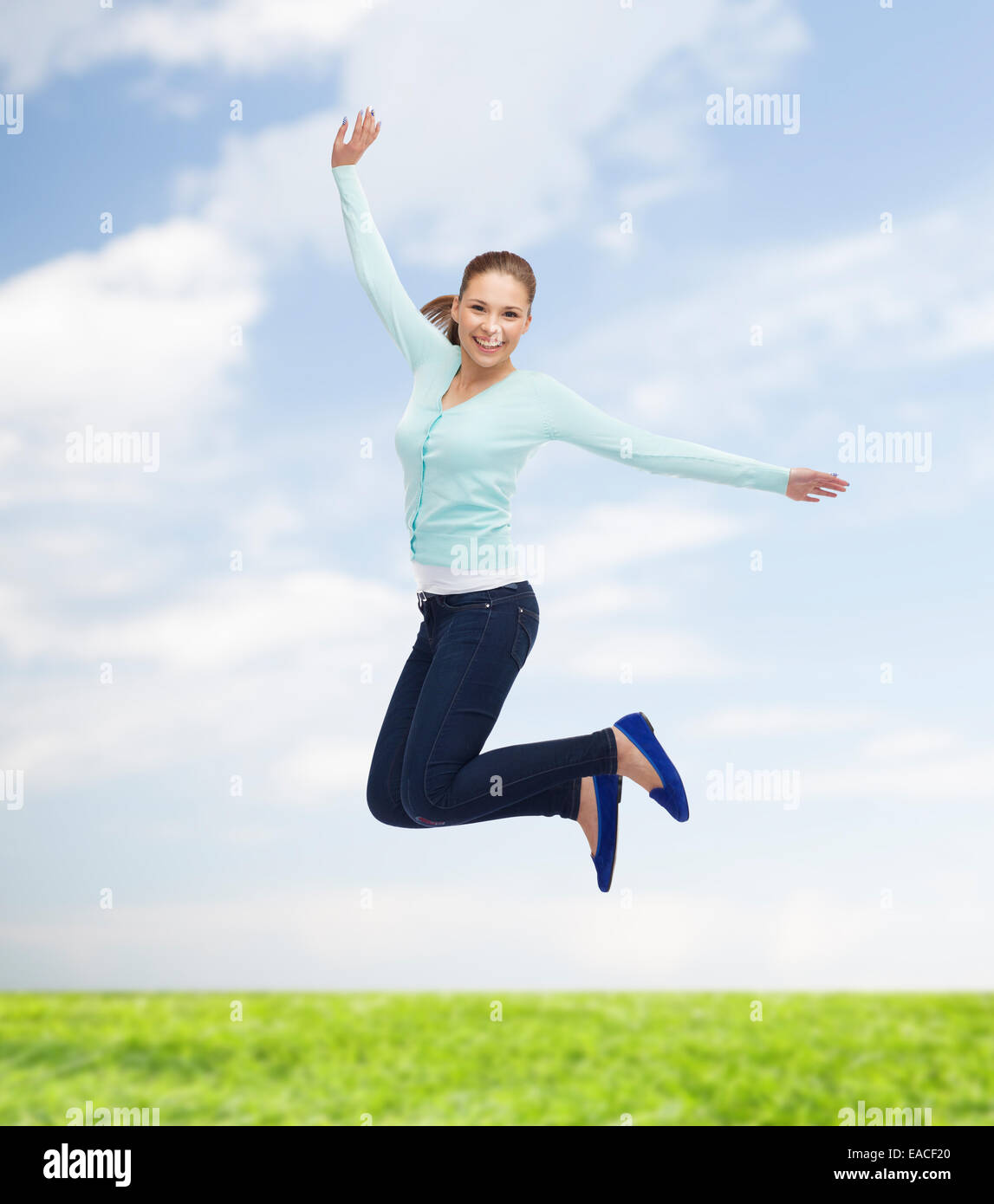 smiling young woman jumping in air Stock Photo - Alamy