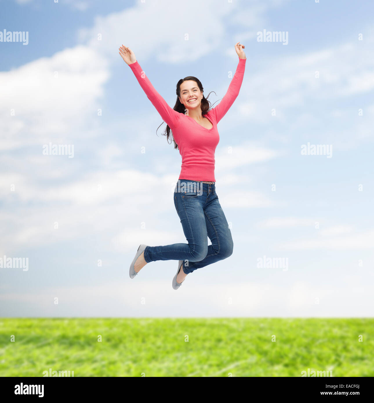 smiling young woman jumping in air Stock Photo - Alamy