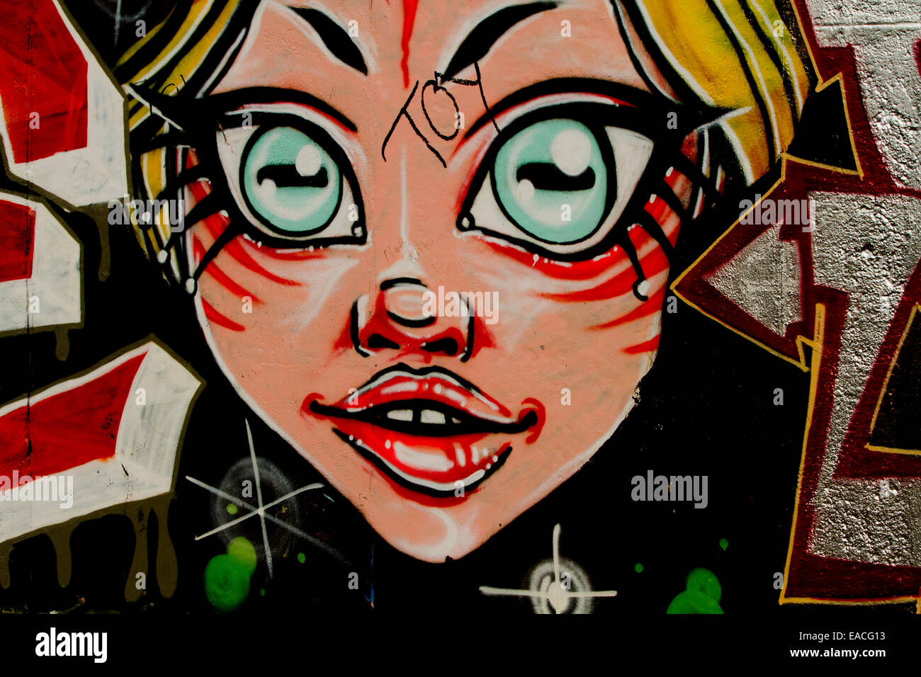 Graffiti street art Berlin wall cartoon girl face Stock Photo