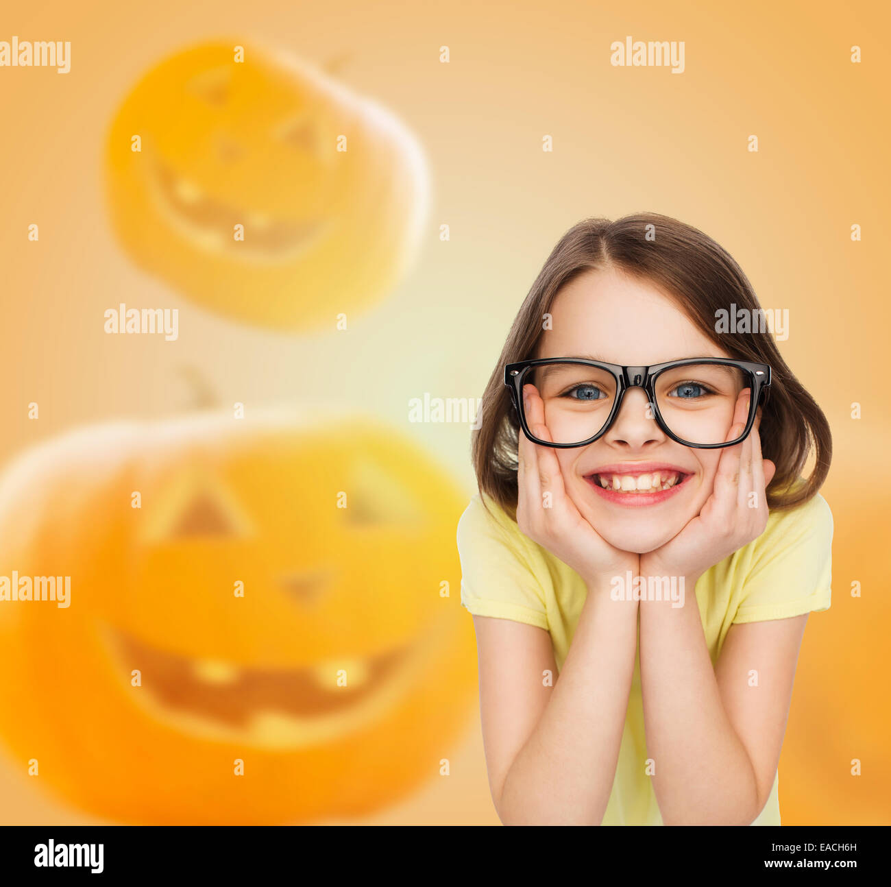 smiling girl in glasses over pumpkins background Stock Photo
