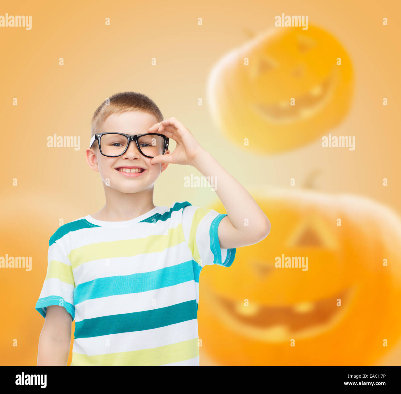 smiling boy in glasses over pumpkins background Stock Photo