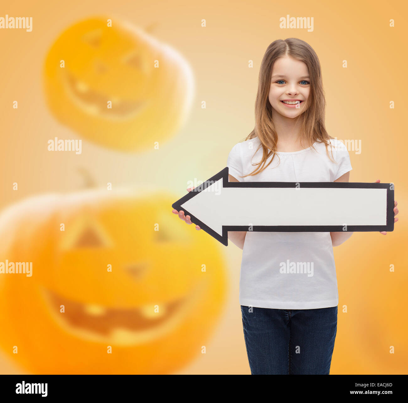 smiling little girl holding big white arrow Stock Photo - Alamy