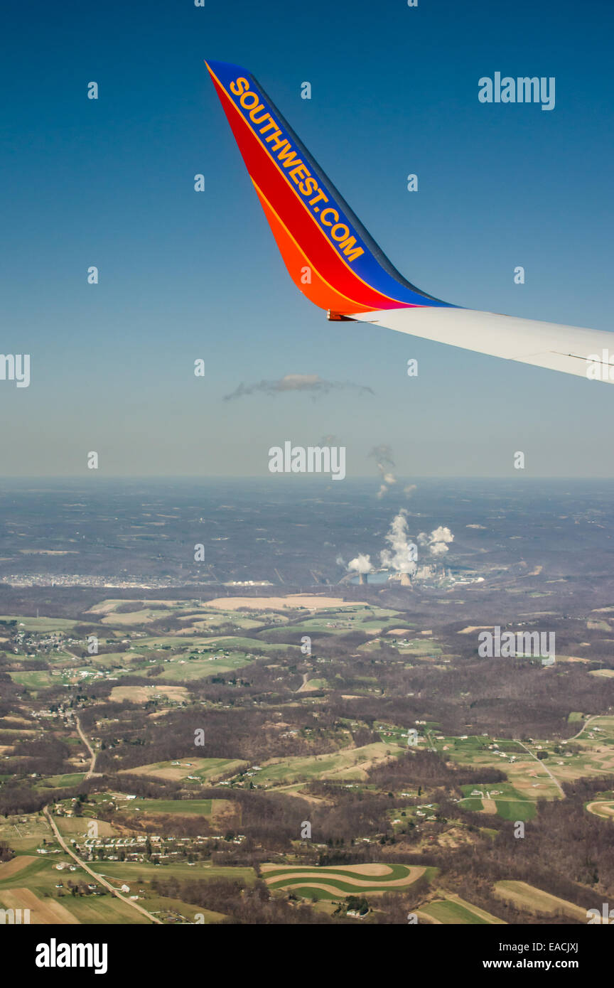 Aerial view of rural farmland with industrial center in background