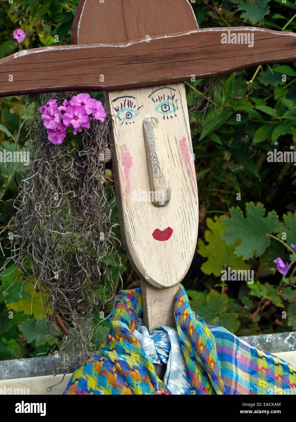 Garden statue and scarecrow dressed up with harvest from community